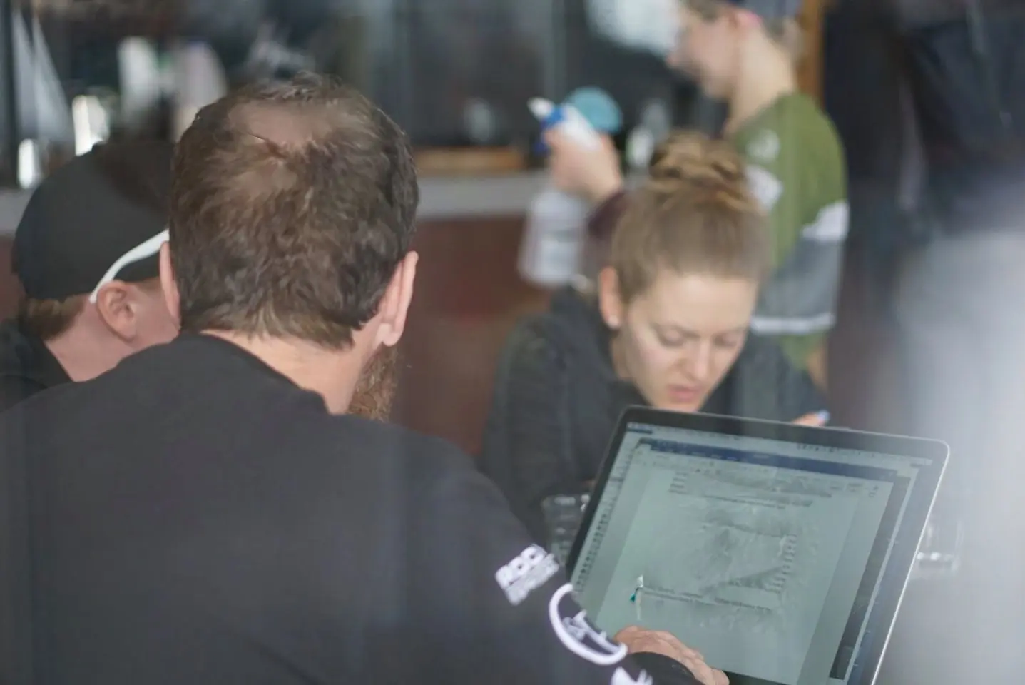 Performance staff reviewing race data on a laptop